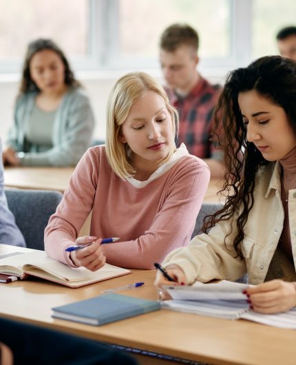 Young students learning together during a class at university classroom.